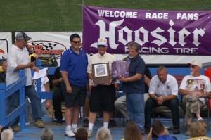 Allan E. Brown is presented with his plaque and Hoosier jacket on stage at Florence Speedway during his induction into the National Dirt Late Model Hall of Fame
